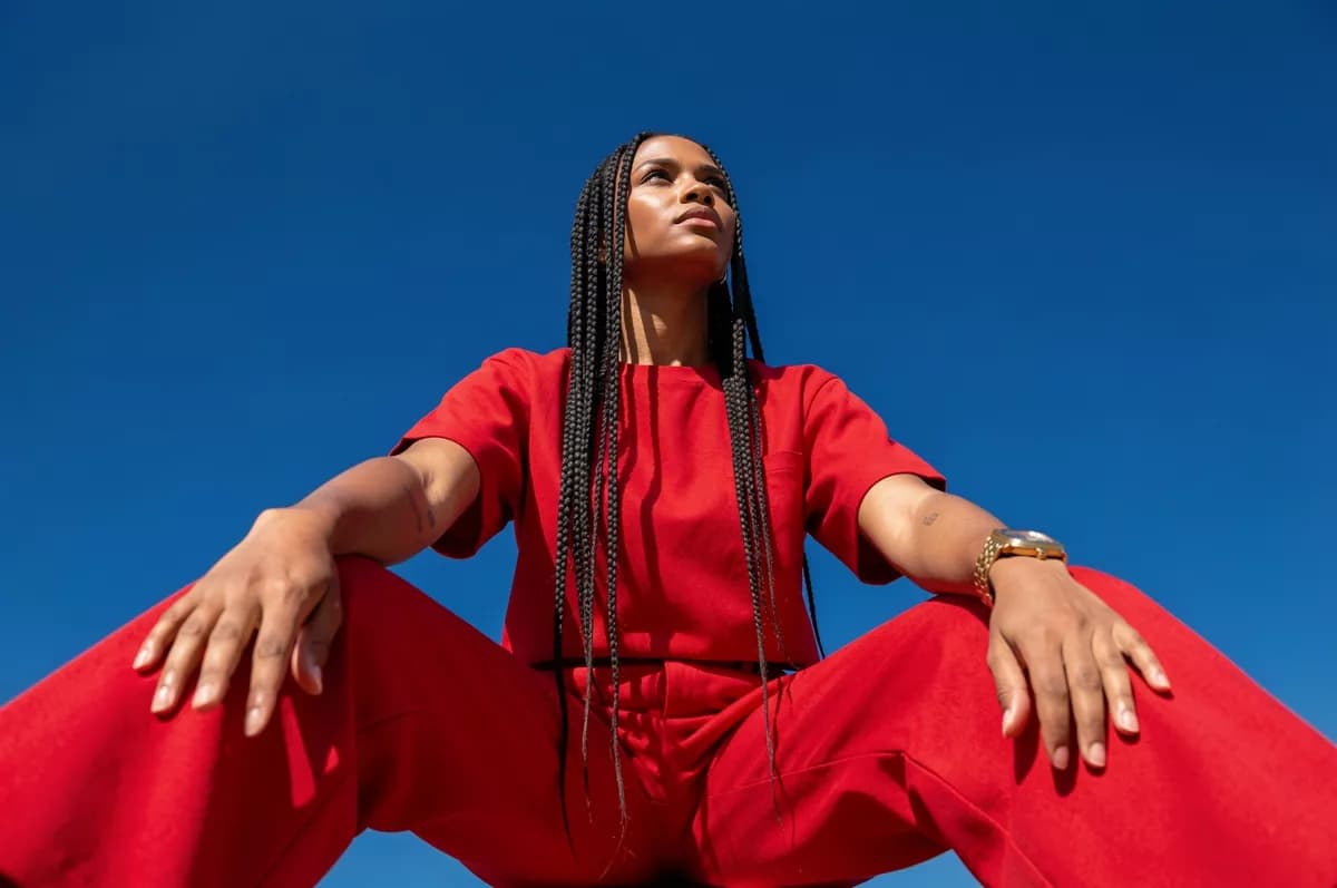 Fashion and beauty: A fashion portrait shot from far below against a cloudless deep blue sky. A woma