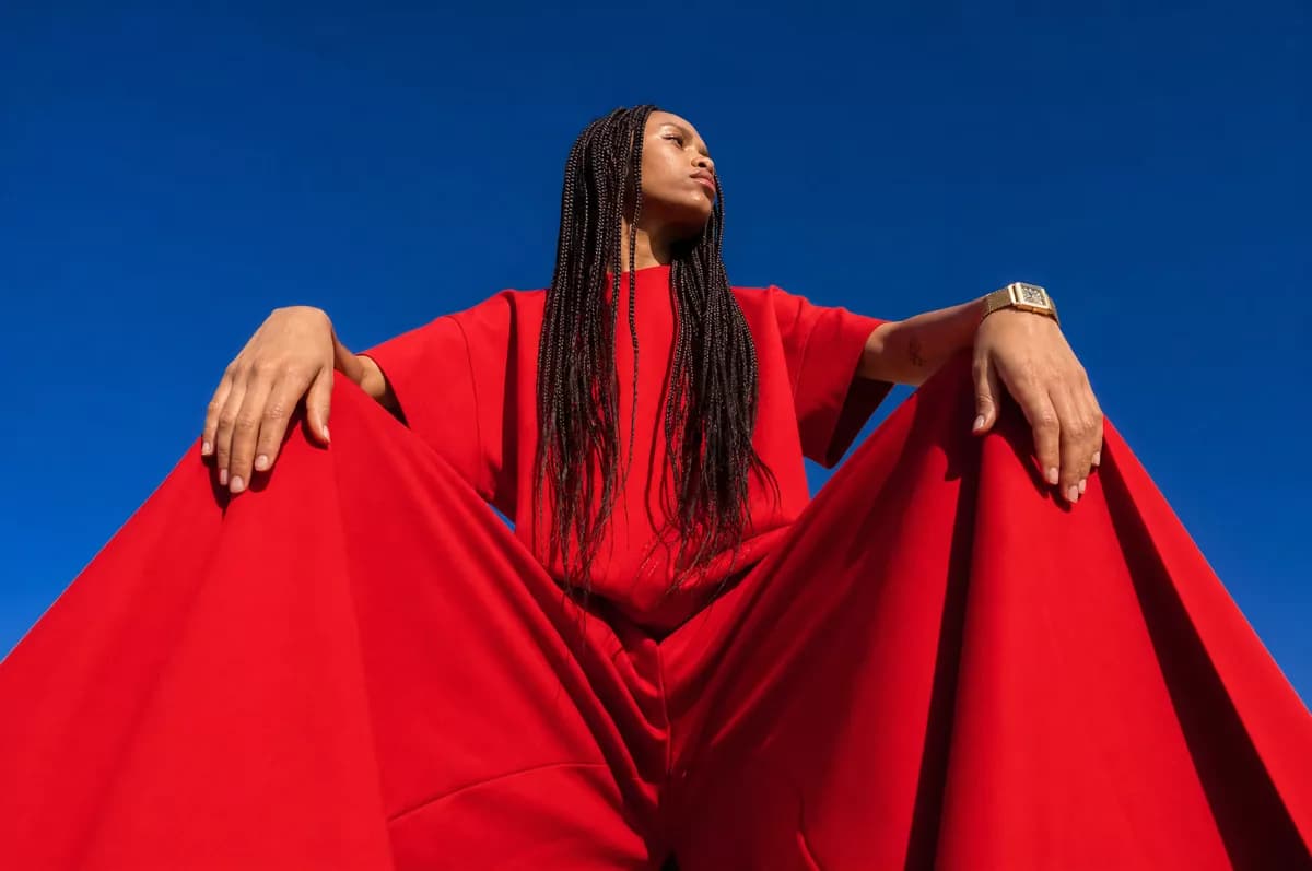 Fashion and beauty: A fashion portrait shot from far below against a cloudless deep blue sky. A woma
