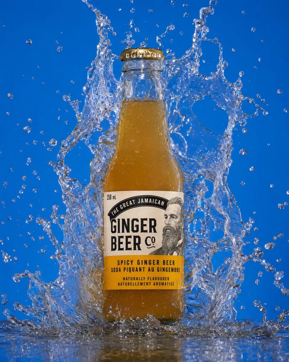Product and e-commerce: A drinks product shot against a flat mid-blue background. A glass bottle of ging