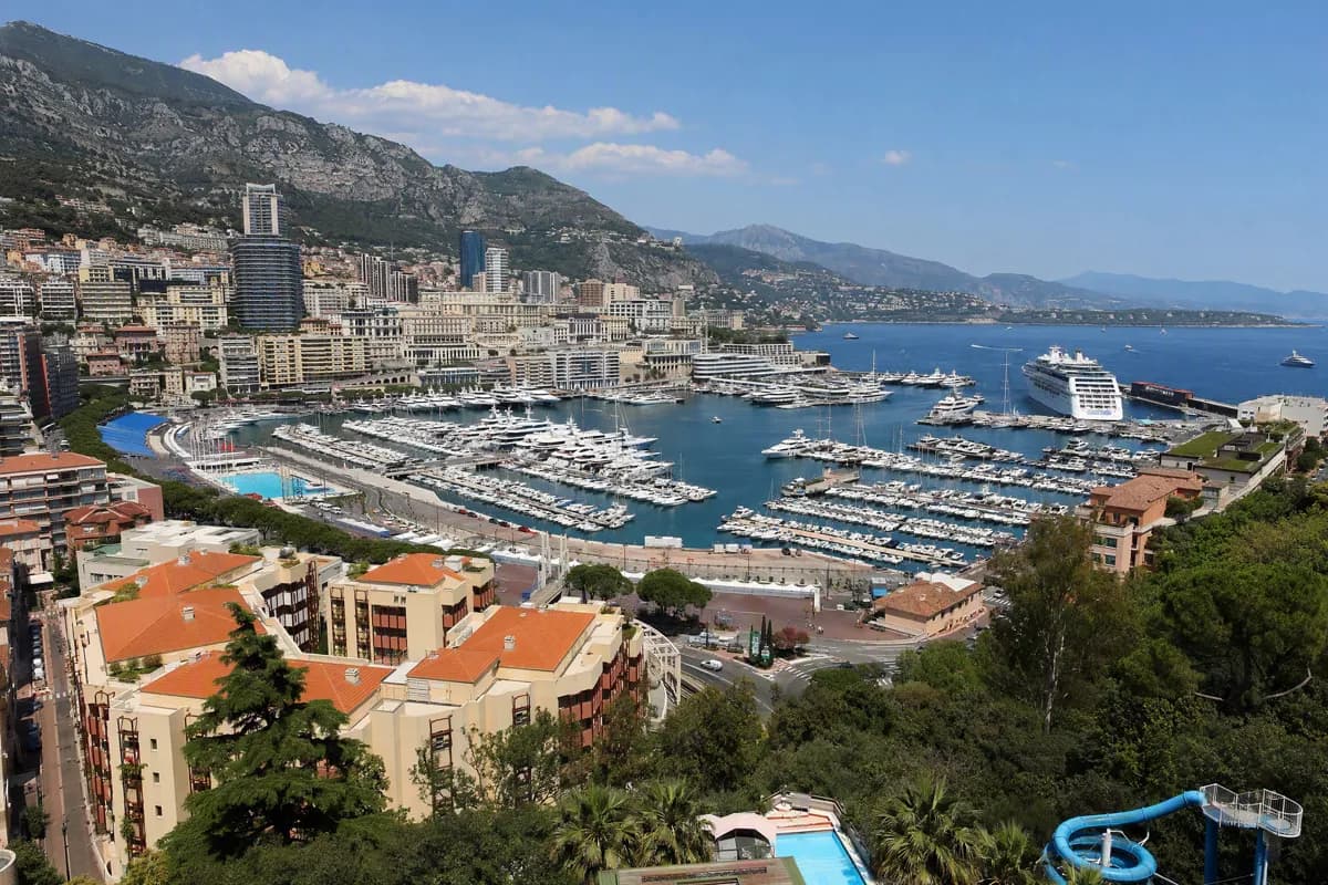 Street and architecture: An elevated wide view of the Monaco harbour from a hillside. In the centre, hund