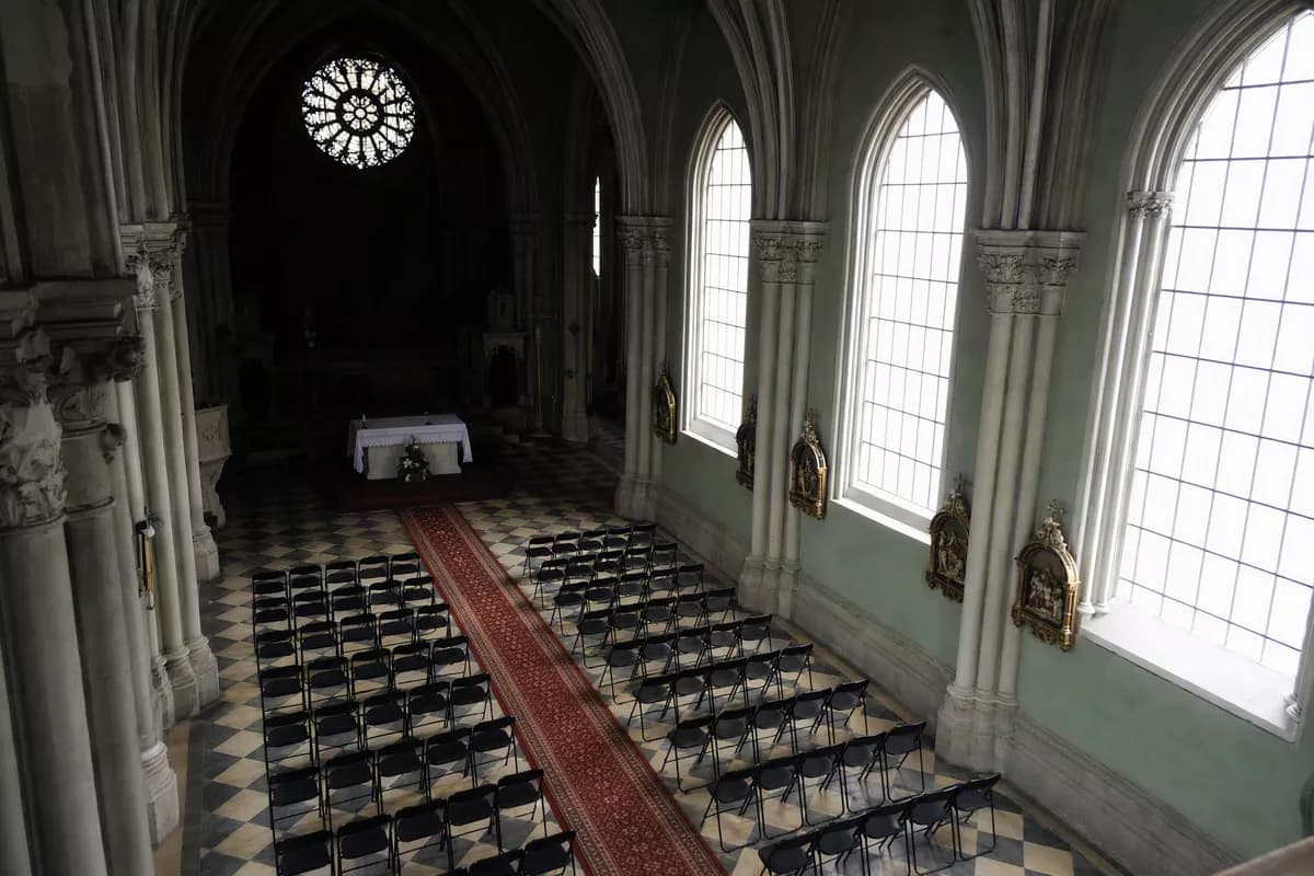 Street and architecture: The interior of a neo-Gothic church seen from a high balcony looking down the na