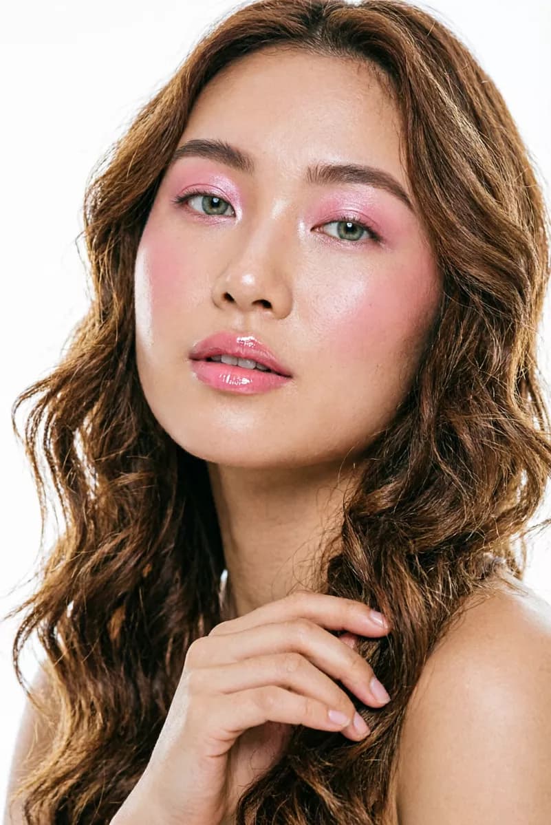 Fashion and beauty: A beauty close-up of a young woman with long wavy caramel-brown hair filling the