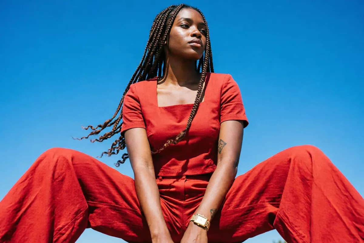Fashion and beauty: A fashion portrait shot from far below against a cloudless deep blue sky. A woma