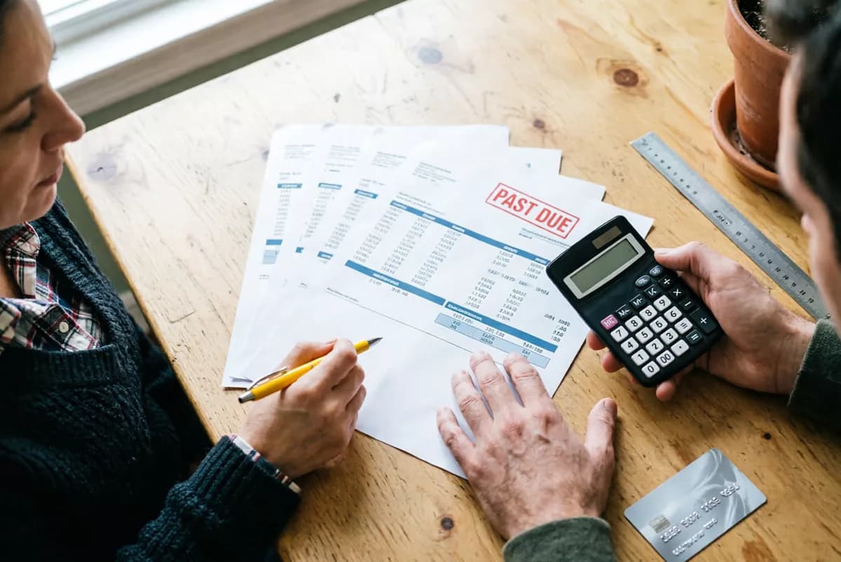 Layout and typography: An overhead view of two people at a light wooden table sorting through paperwork