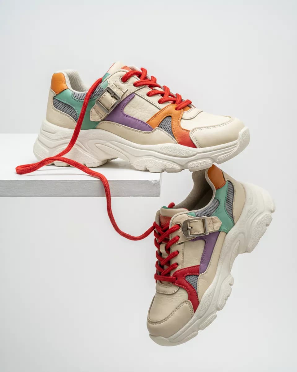 Qwen Image 2.0 Pro — Product and e-commerce: Two chunky sneakers on a white seamless background with a white plinth. One rest