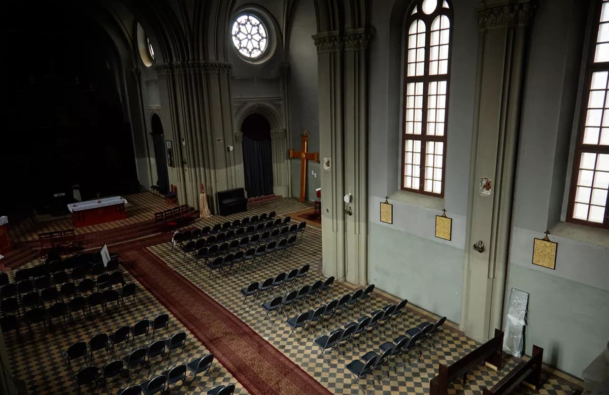 Real photograph — Street and architecture: The interior of a neo-Gothic church seen from a high balcony looking down the na