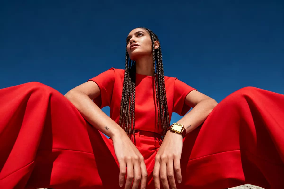 Seedream 4.0 — Fashion and beauty: A fashion portrait shot from far below against a cloudless deep blue sky. A woma