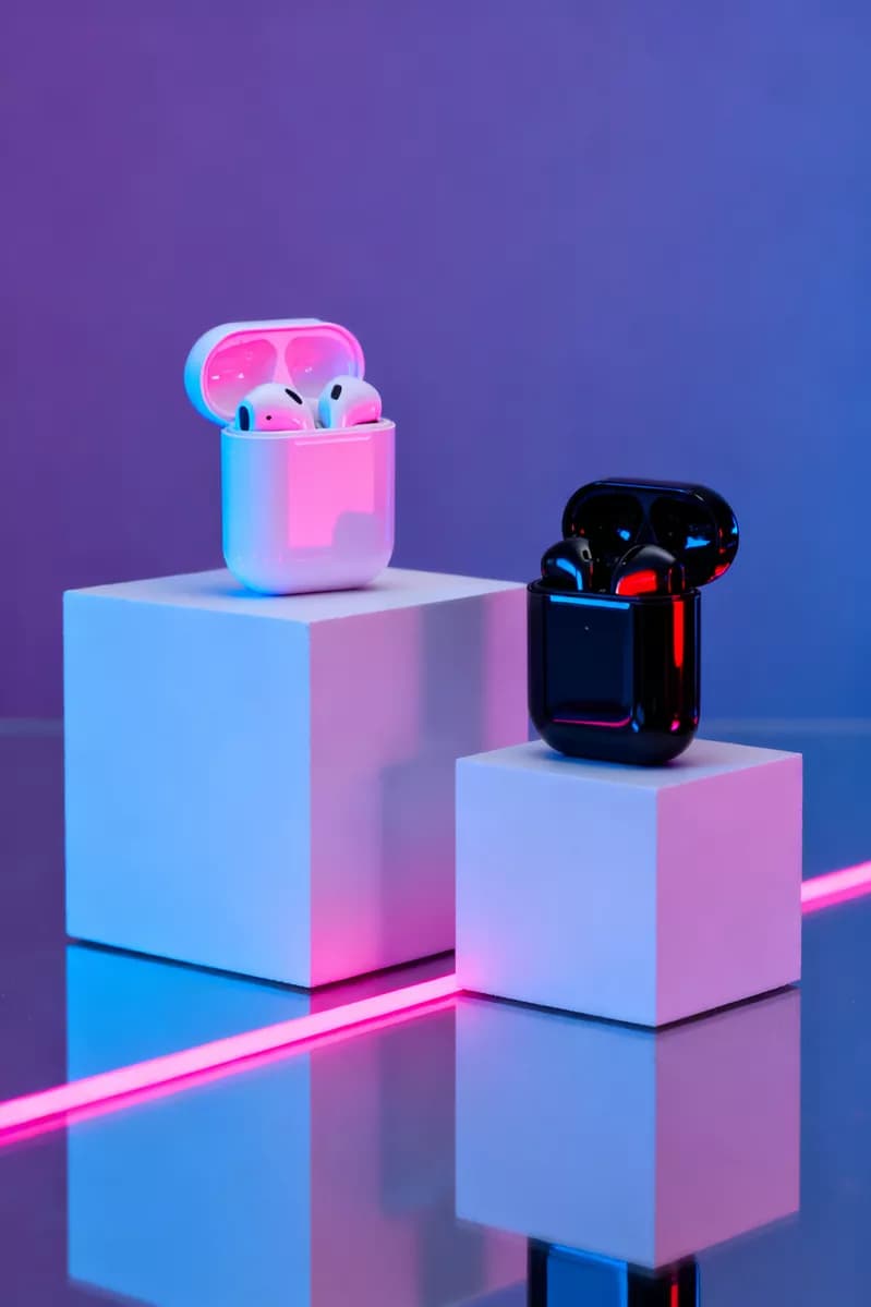Product and e-commerce: Two wireless earbud charging cases displayed on white geometric podiums, both op