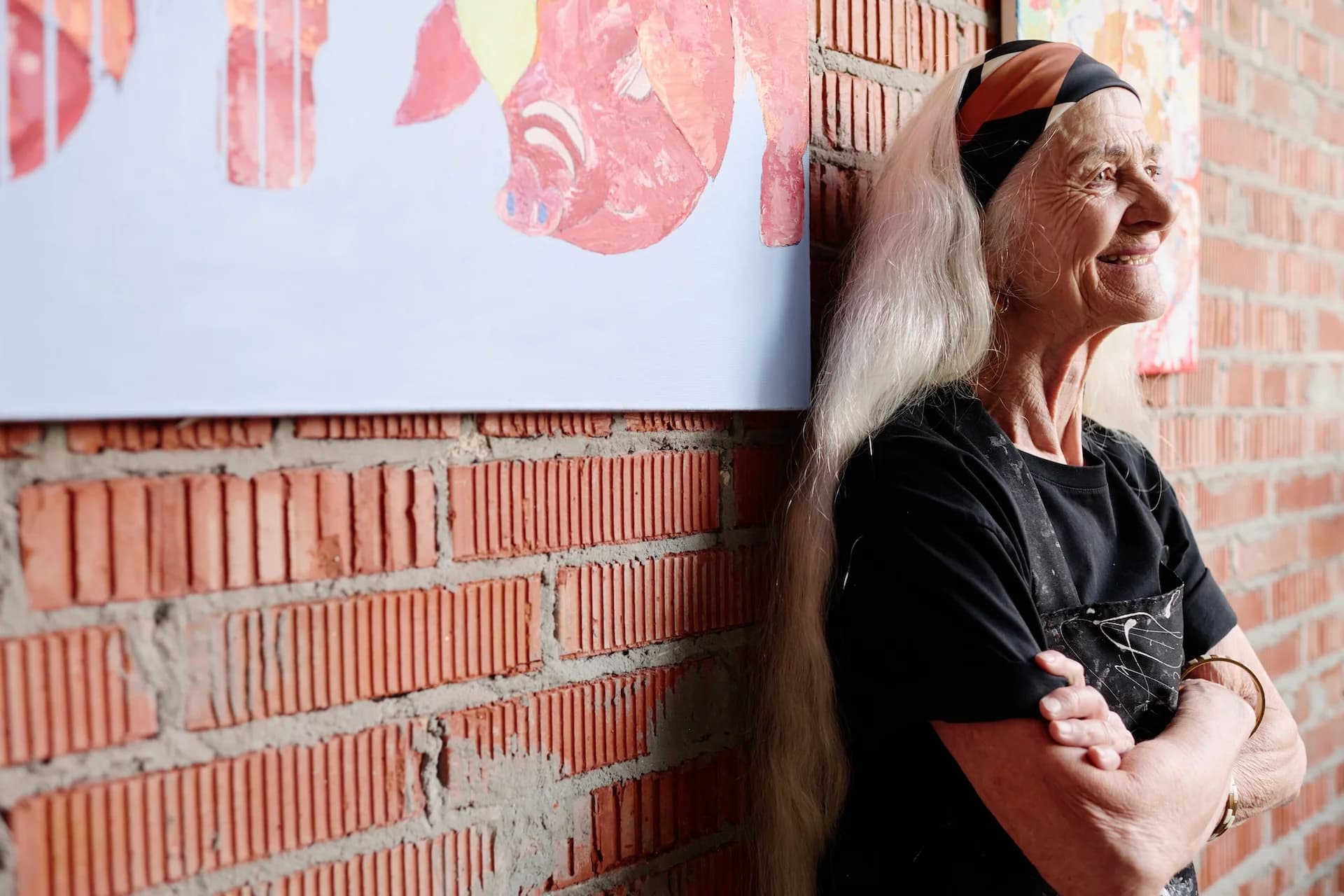 Older woman by brick wall